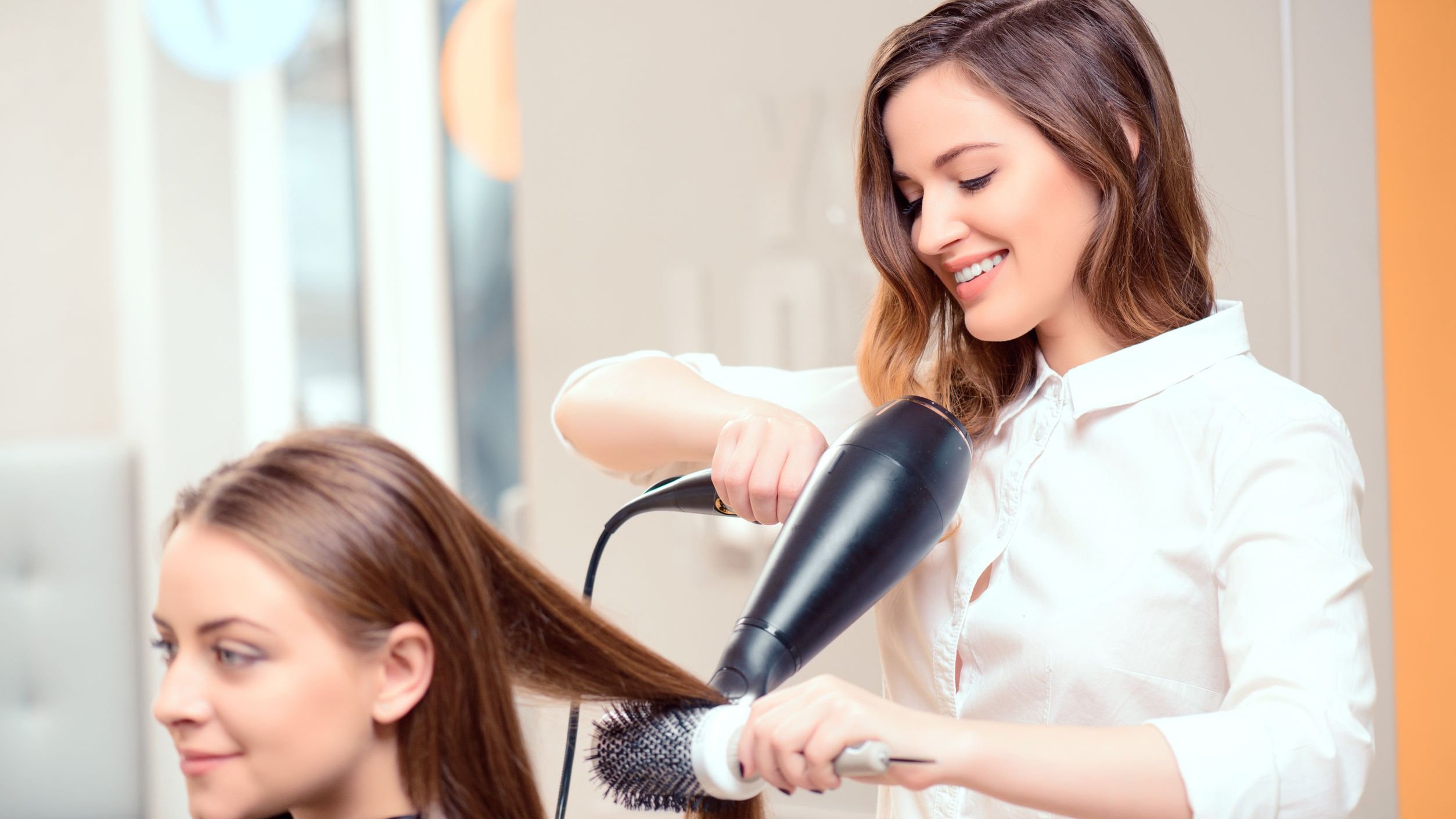 Cabeleireira fazendo escova no cabelo da cliente