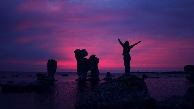 Pixabay Pessoa de braços abertos sobre pedra