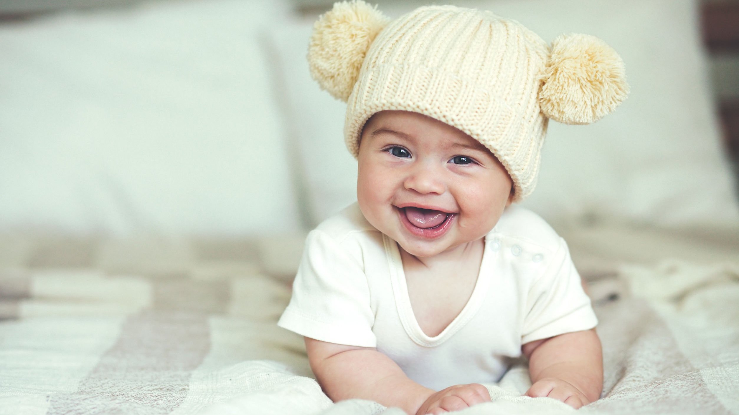 Bebê deitado na cama sorrindo