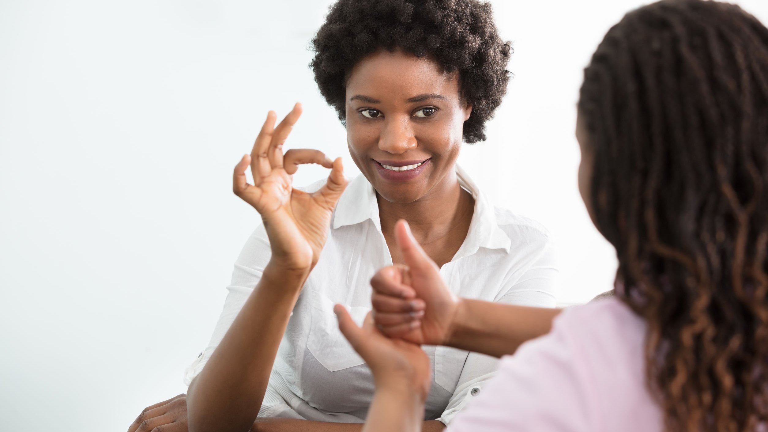 Duas mulheres se comunicando por linguagem de sinais