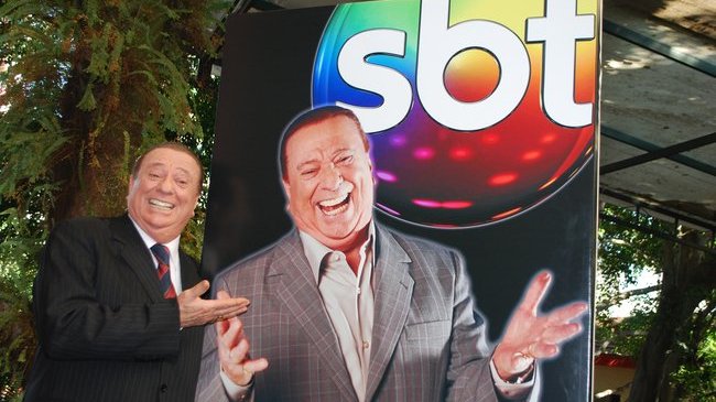 Raul Gil ao lado de seu totem com logo do SBT