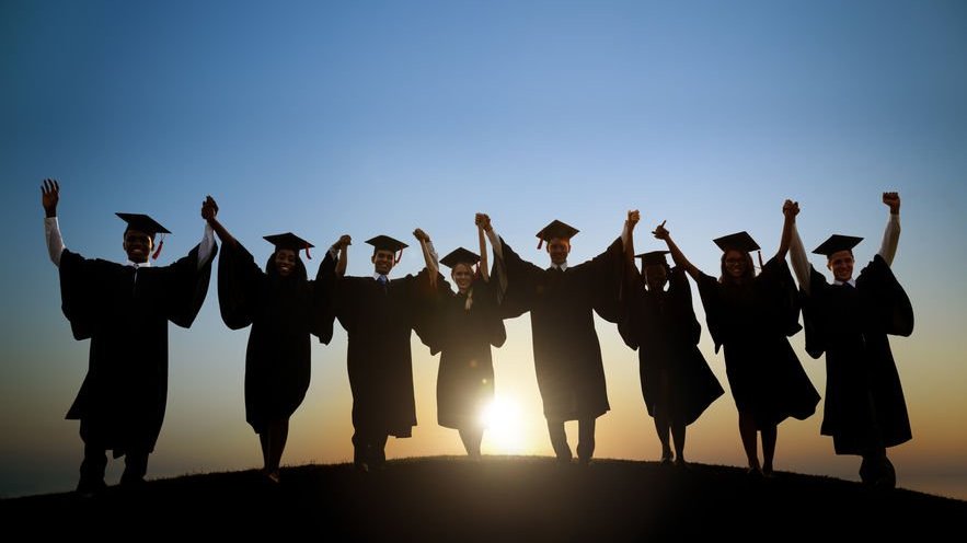 Amigos com becas e chapéu de formatura