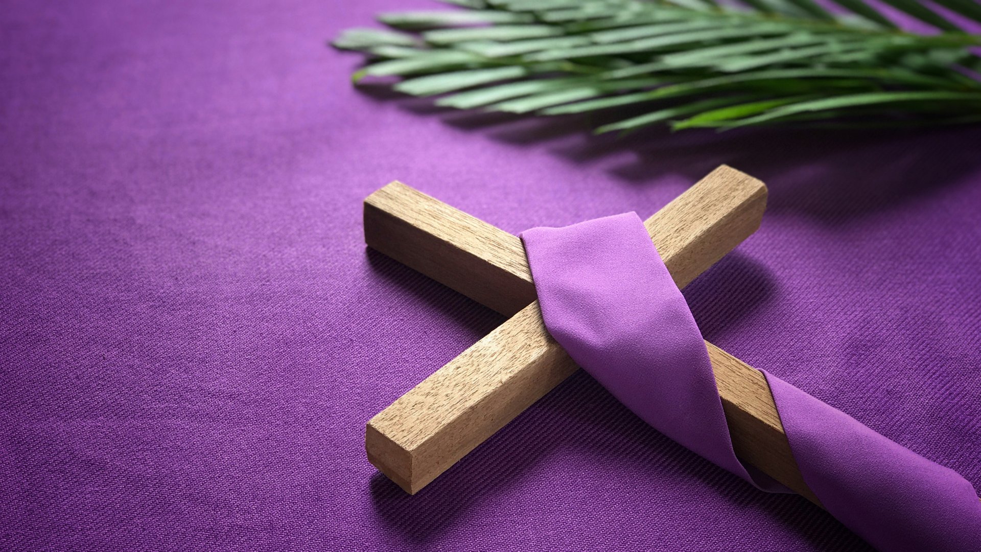 Cruz de madeira enrolada em tecido roxo