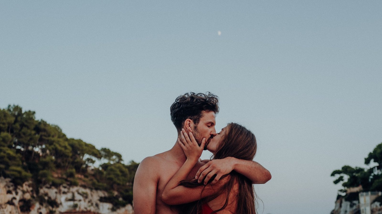 Scopio / Canva PRO Homem e mulher brancos se beijando.