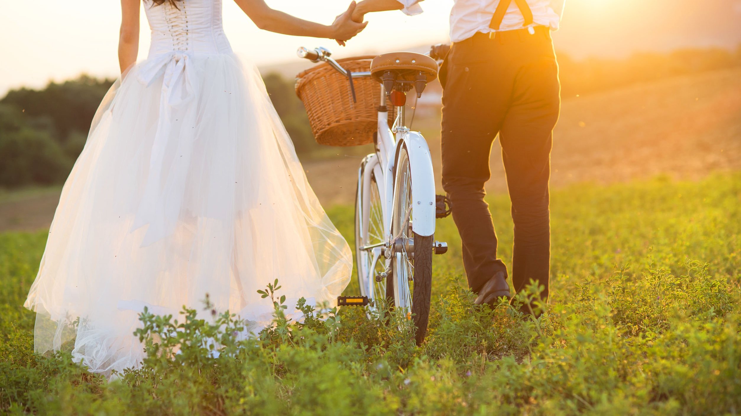Marido e esposa caminhando em um parque com uma bicicleta.