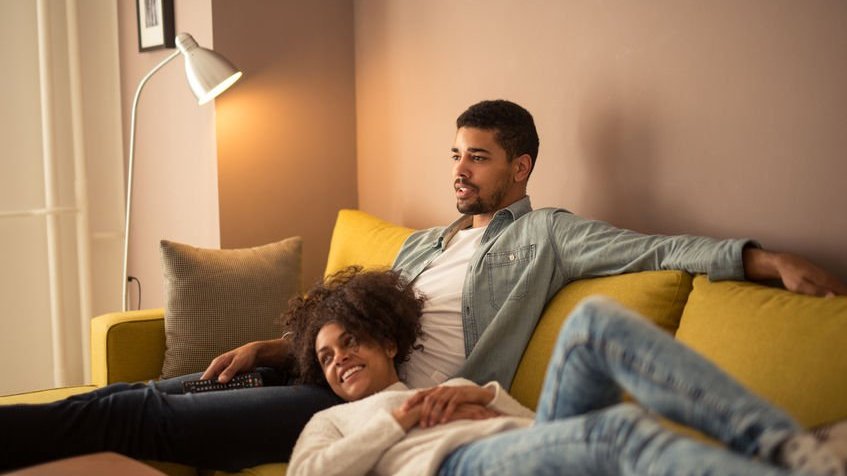 Casal no sofá assistindo TV