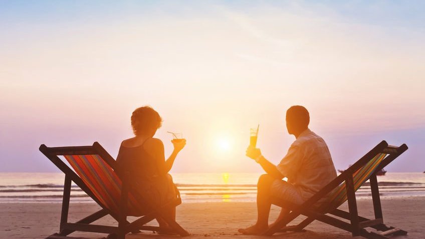 Casal na praia observando o pôr do sol