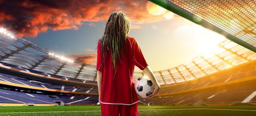 Menina em um estádio de futebol com a bola na mão