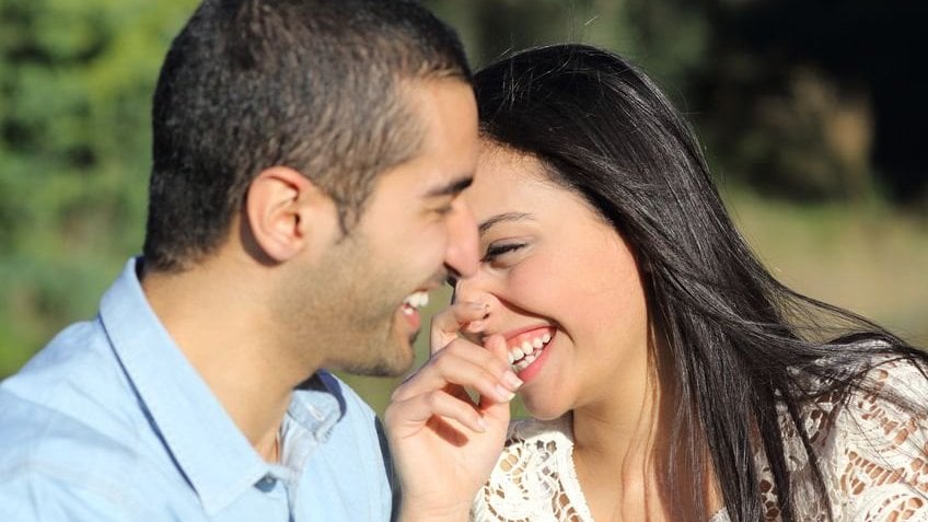 Casal sorrindo um para o outro