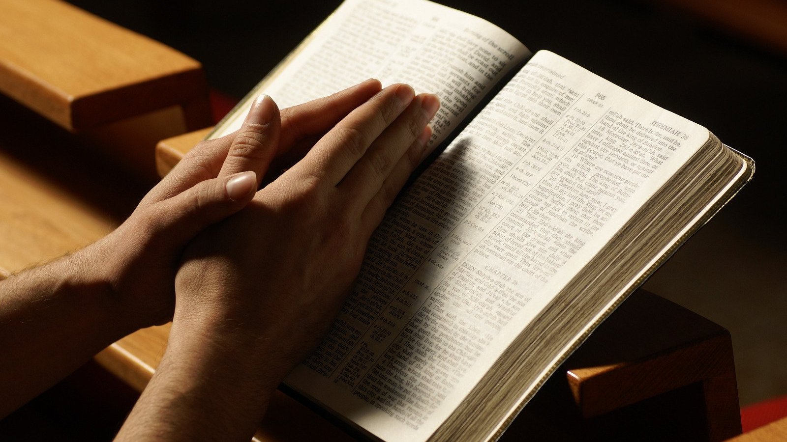 Святое чтение слушать. Библия в руках. Человек молится с Библией. Человек с Библией в руках. Человек молится над Библией.