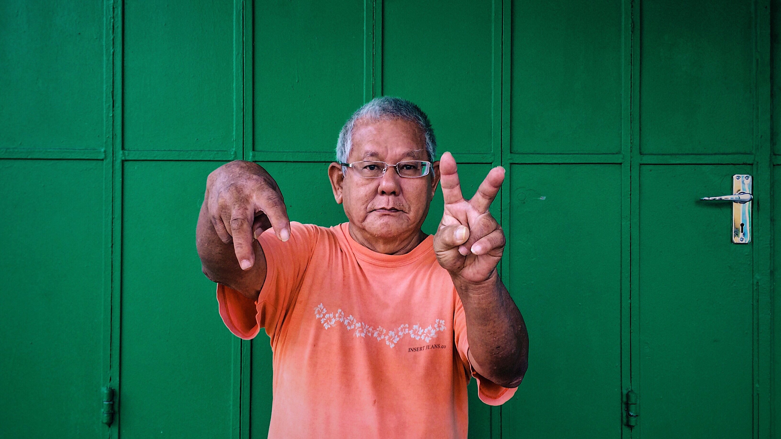 homem fazendo símbolo de paz e amor com as mãos