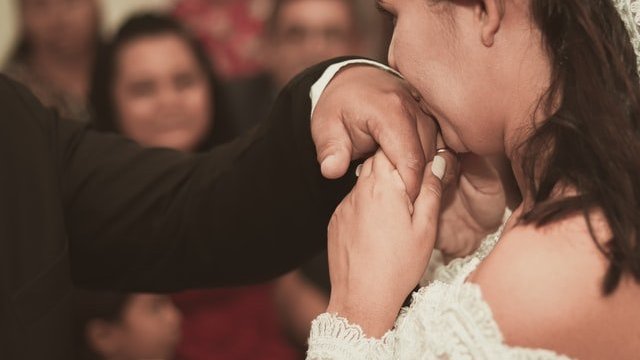 Noiva beijando mão de noivo