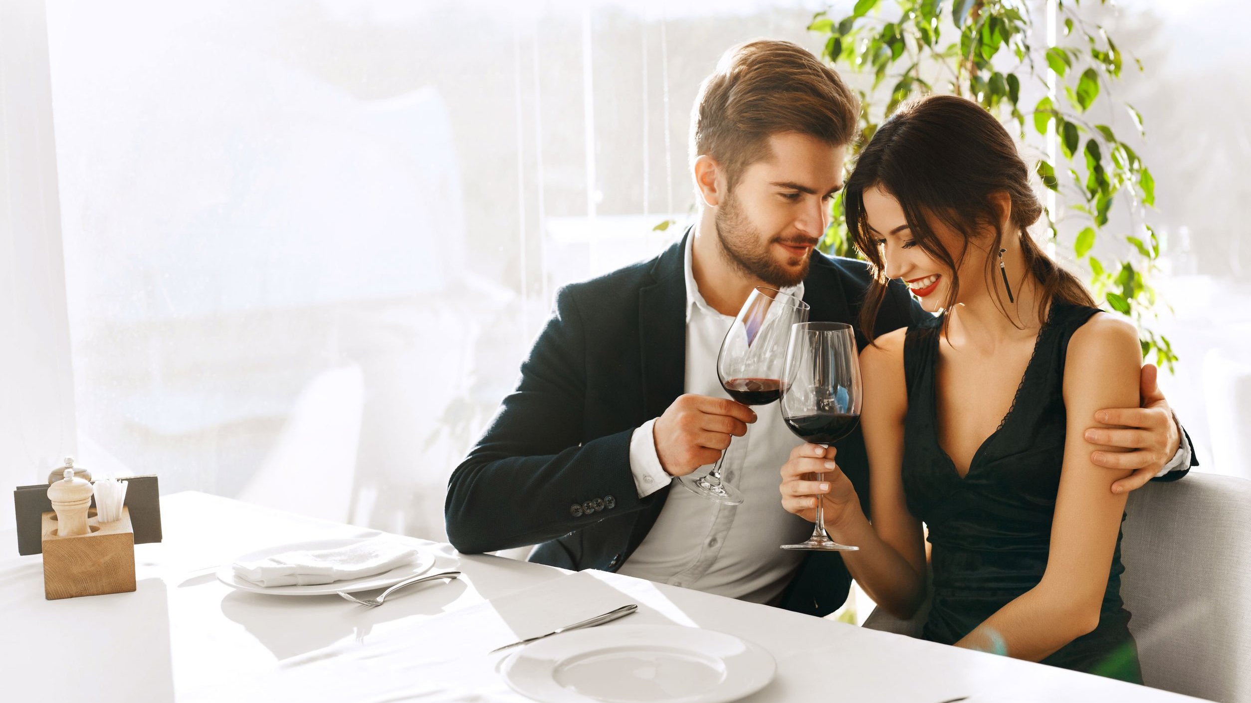 Casal em restaurante, conversando e bebendo vinho.