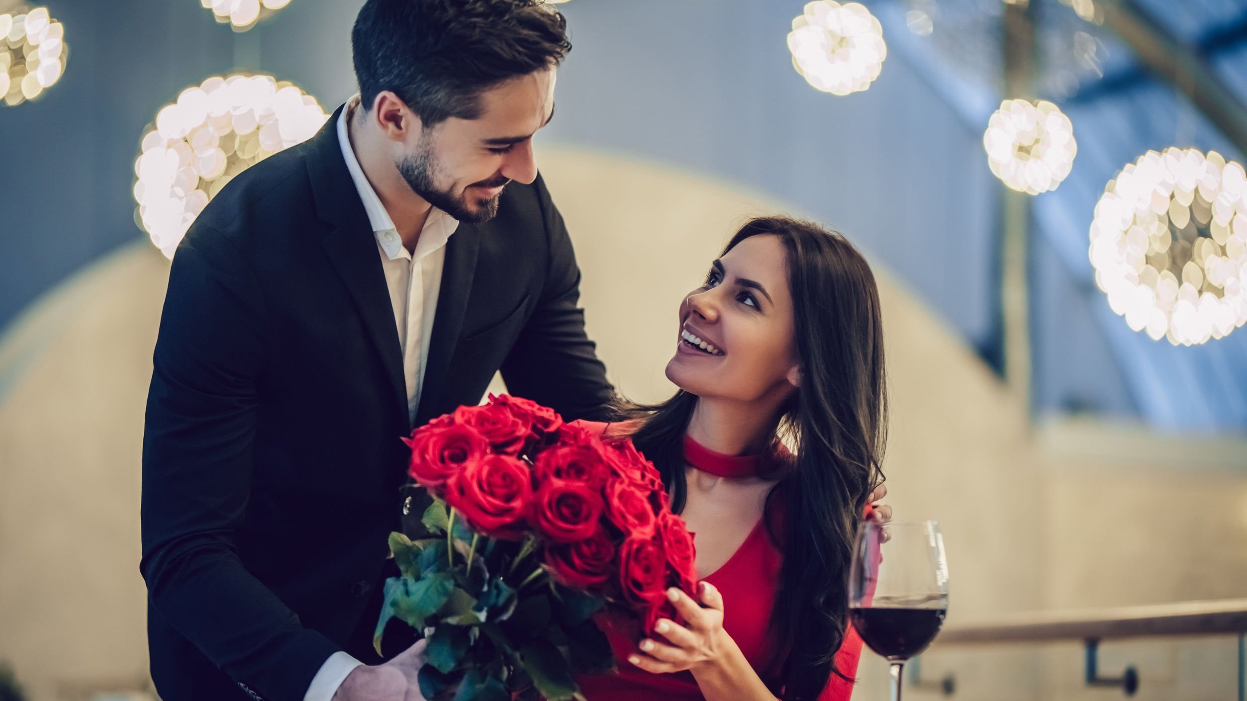 Foto de homem entregando buque de rosas para mulher