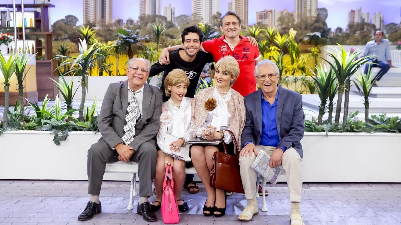 Foto de personagens do programa - A praça é nossa sentados em banco posando para foto