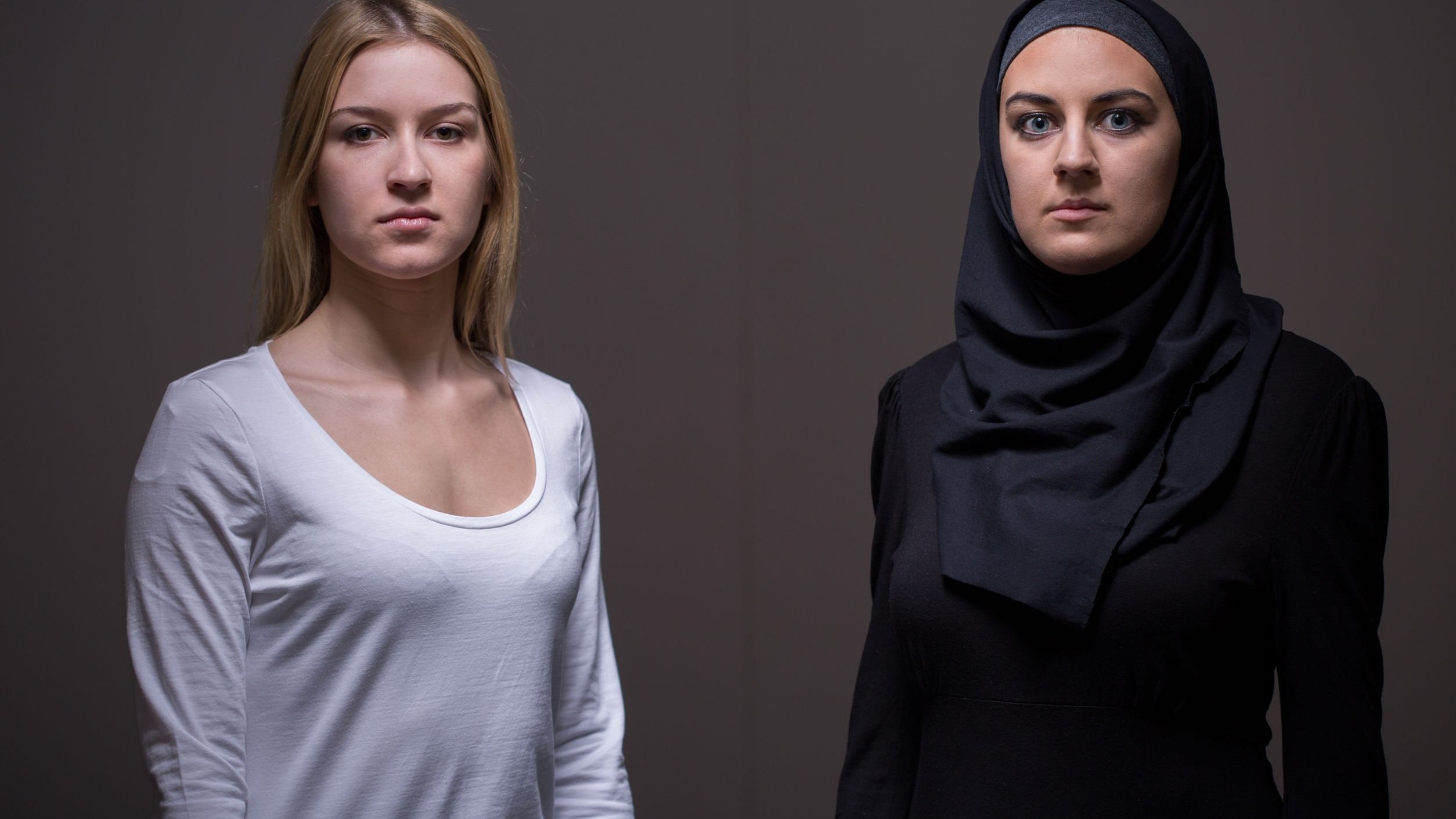 Duas mulheres, uma vestindo roupas comum e outra vestindo burca