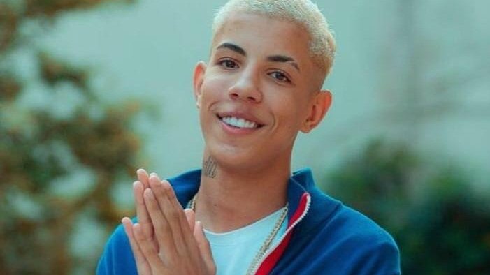 Mc Don Juan sorrindo  e esfregando as mãos