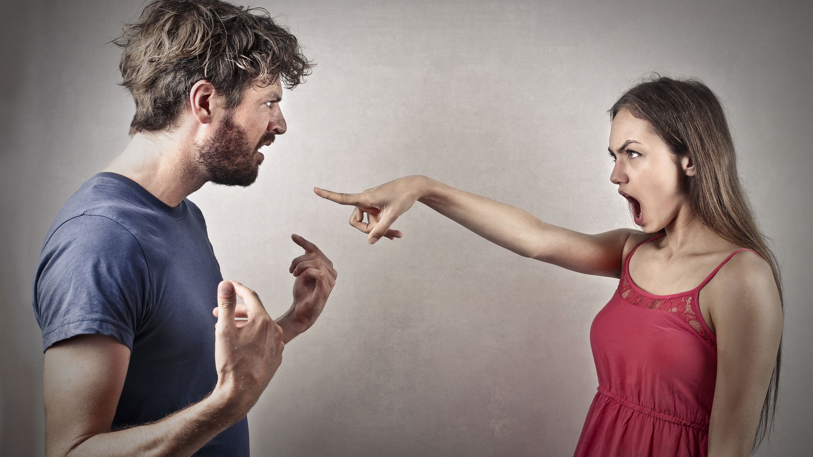 Mulher brava apontando para homem enquanto discutem