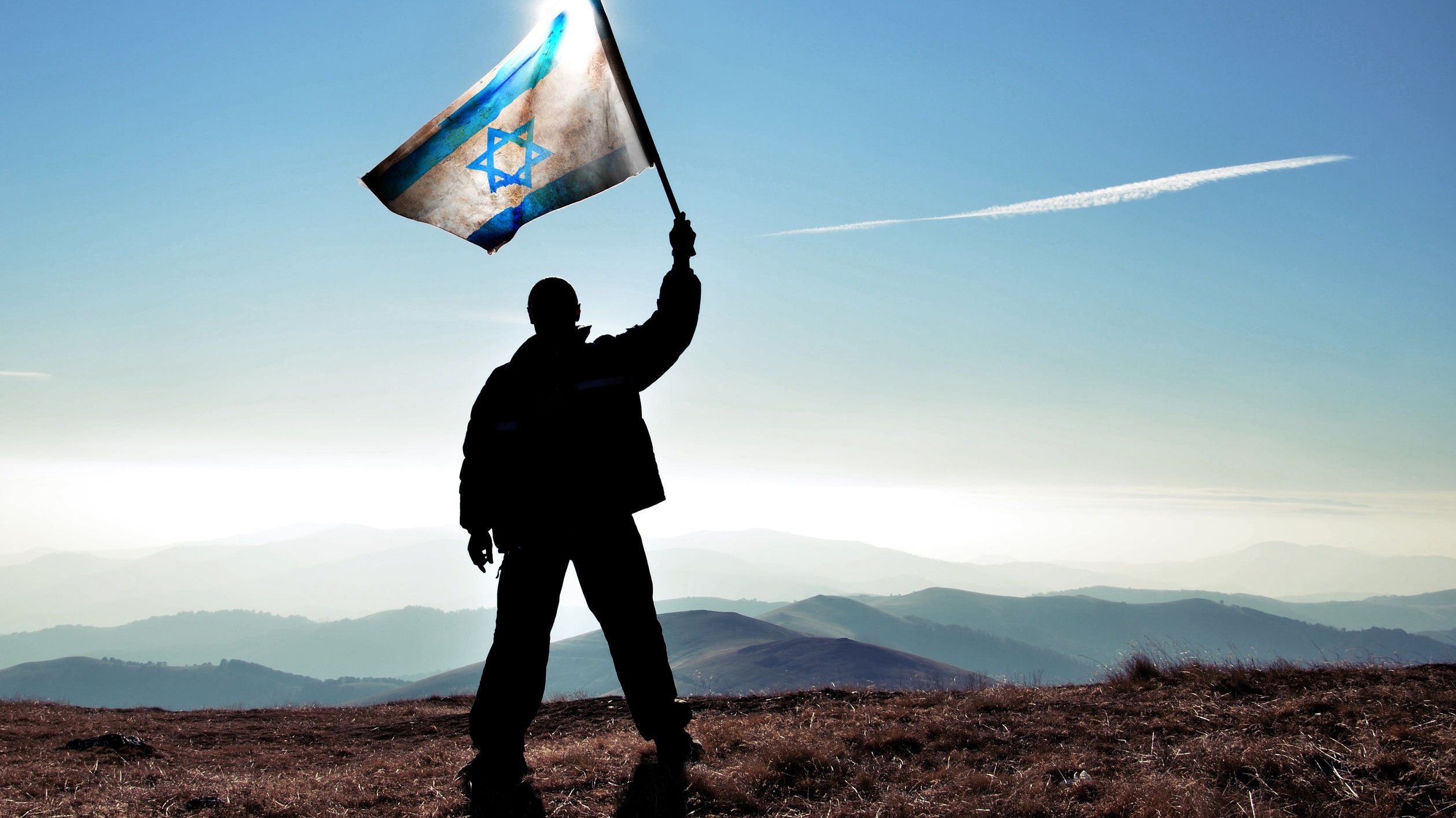 Silhueta de homem levantando a bandeira de Israel