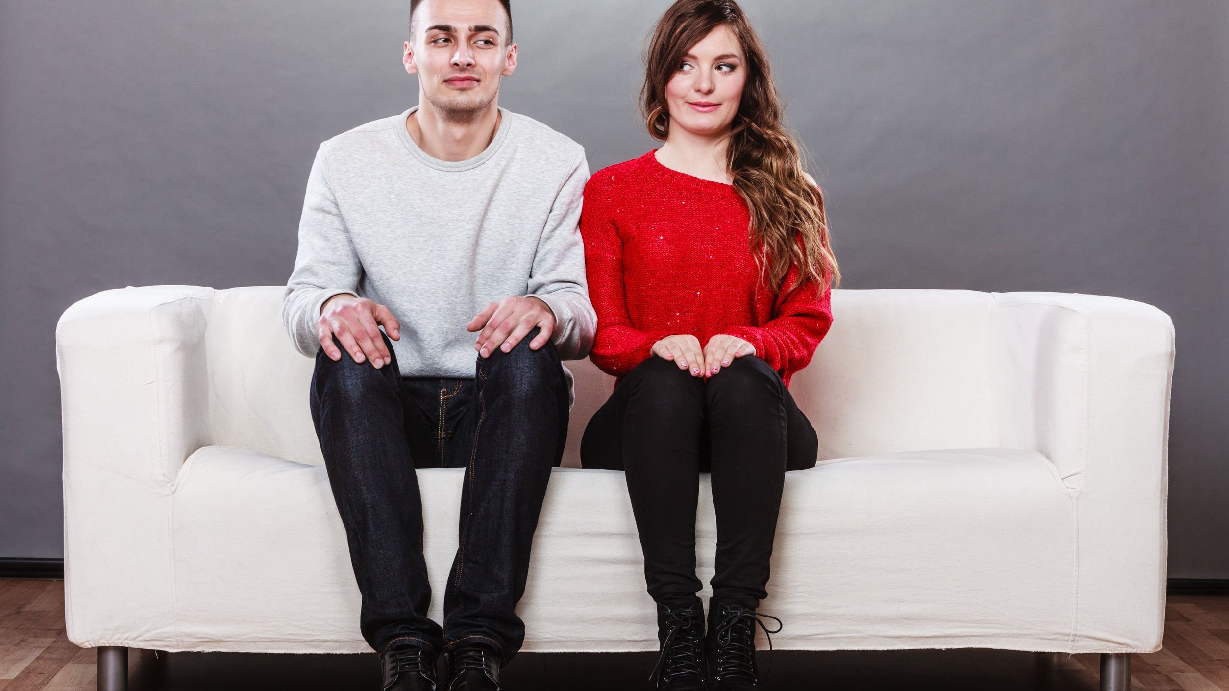 Homem e mulher sentados em sofá branco