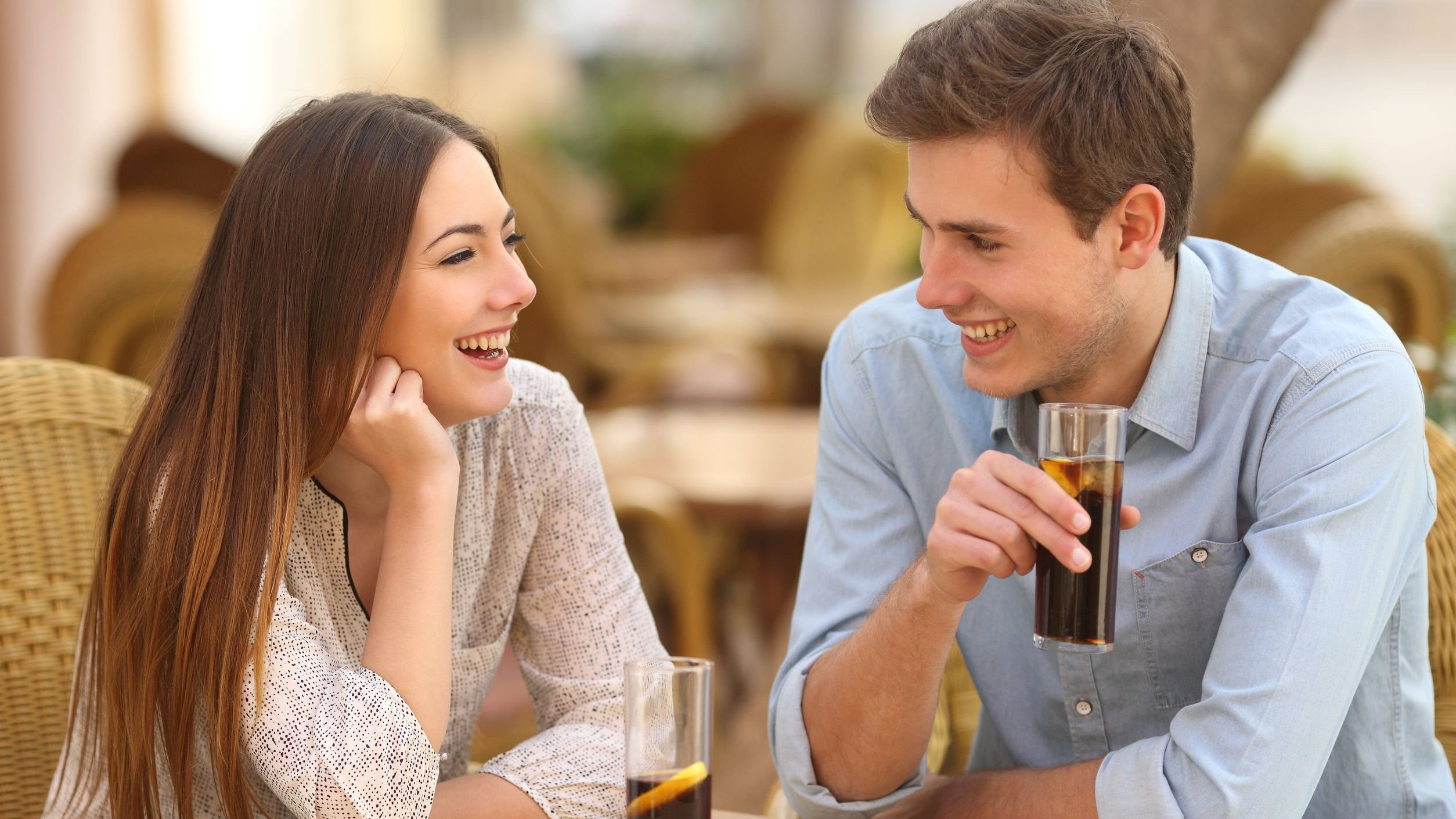 Homem e mulher conversando enquanto estão sentados em mesa de restaurante