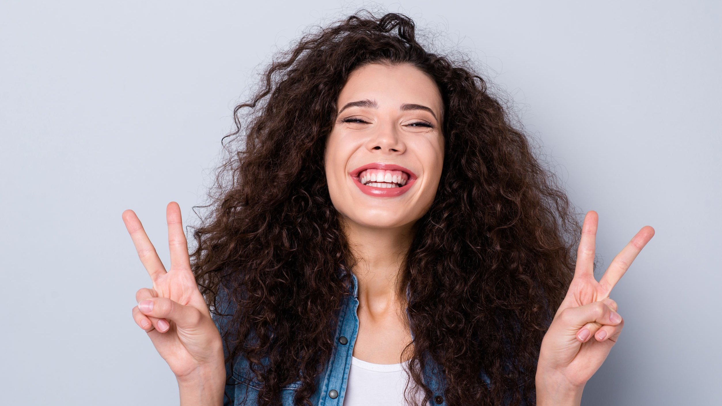 Mulher de cabelos cacheados sorrindo