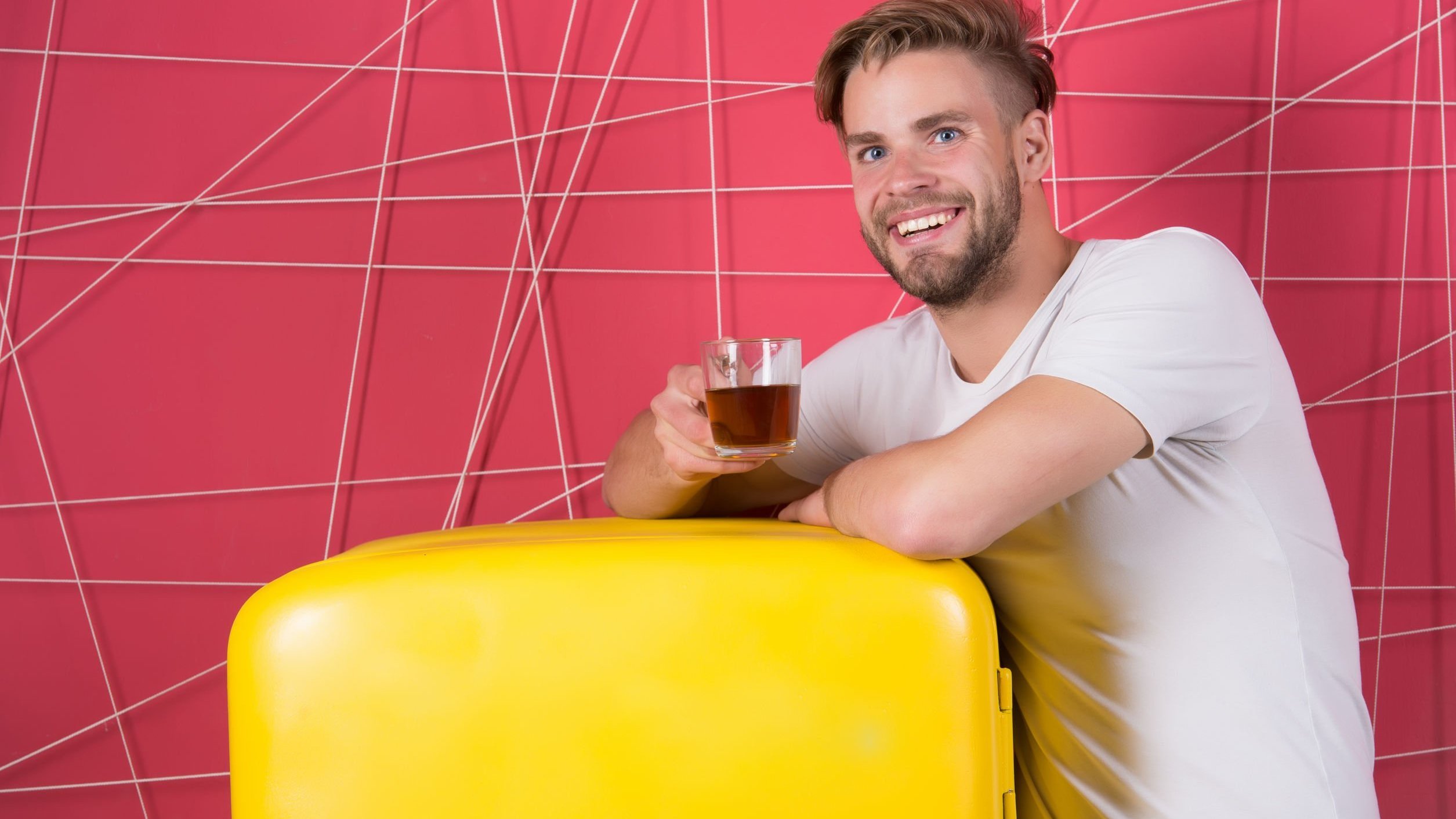 Homem sorrindo segurando copo com bebida