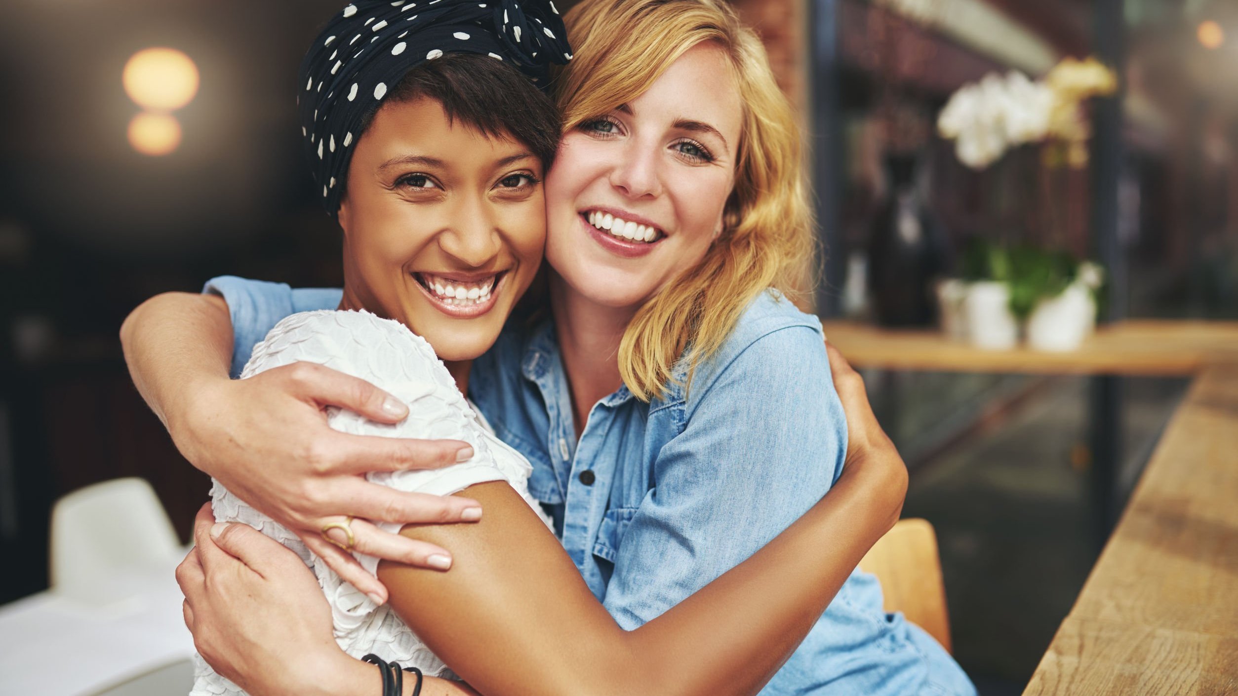 Amigas se abraçando e sorrindo