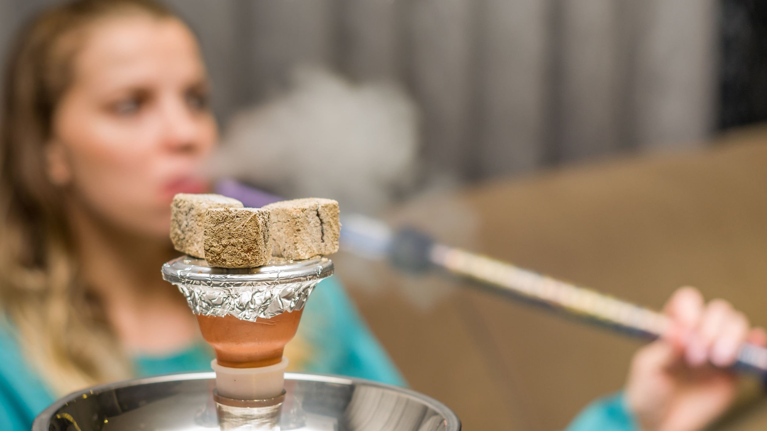 Foto desfocada de mulher fumando narguilé