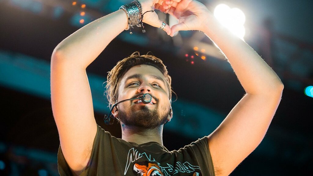 Luan Santana no palco fazendo coração com as mãos