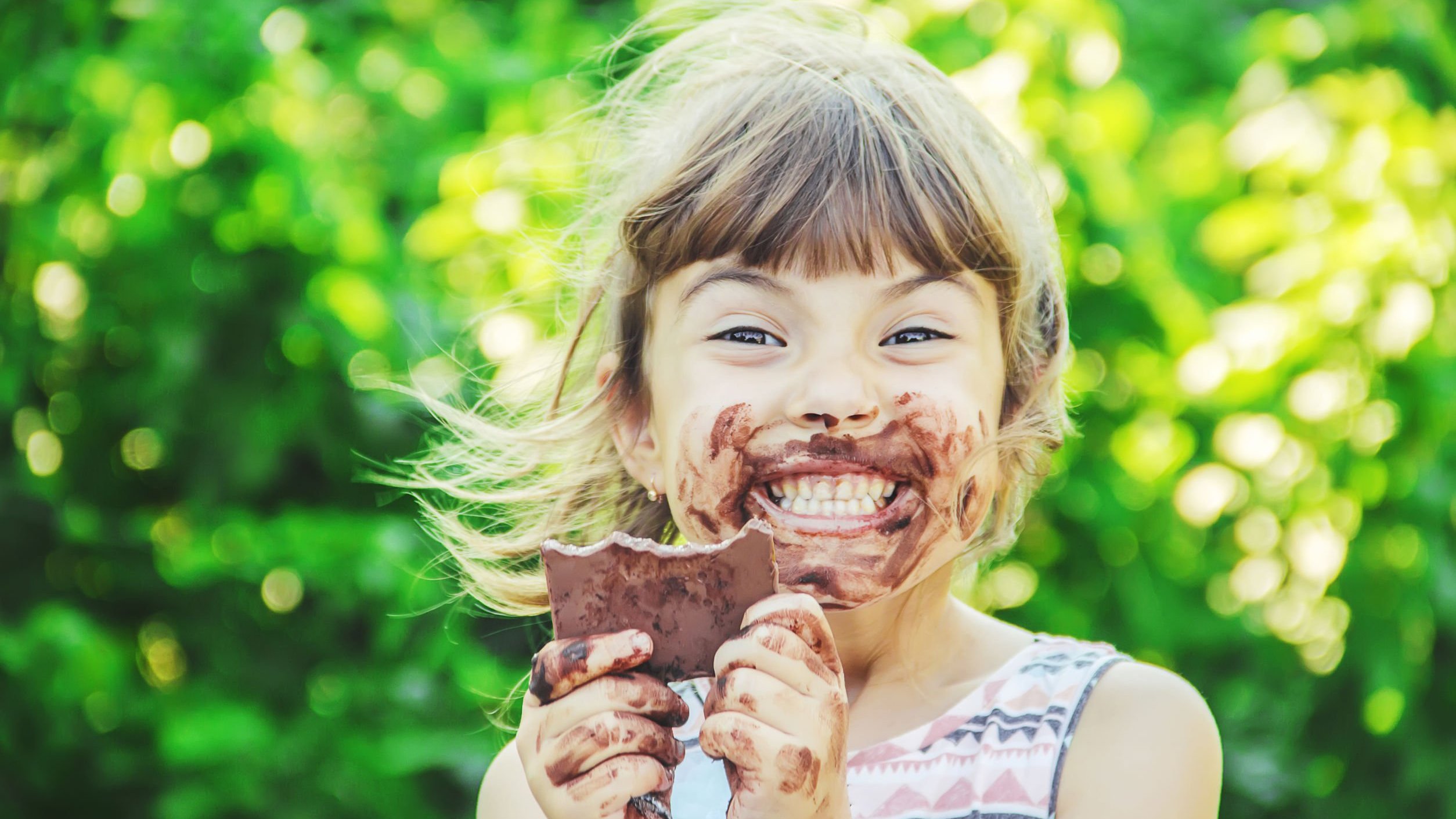 Menina comendo chocolate toda lambrecada