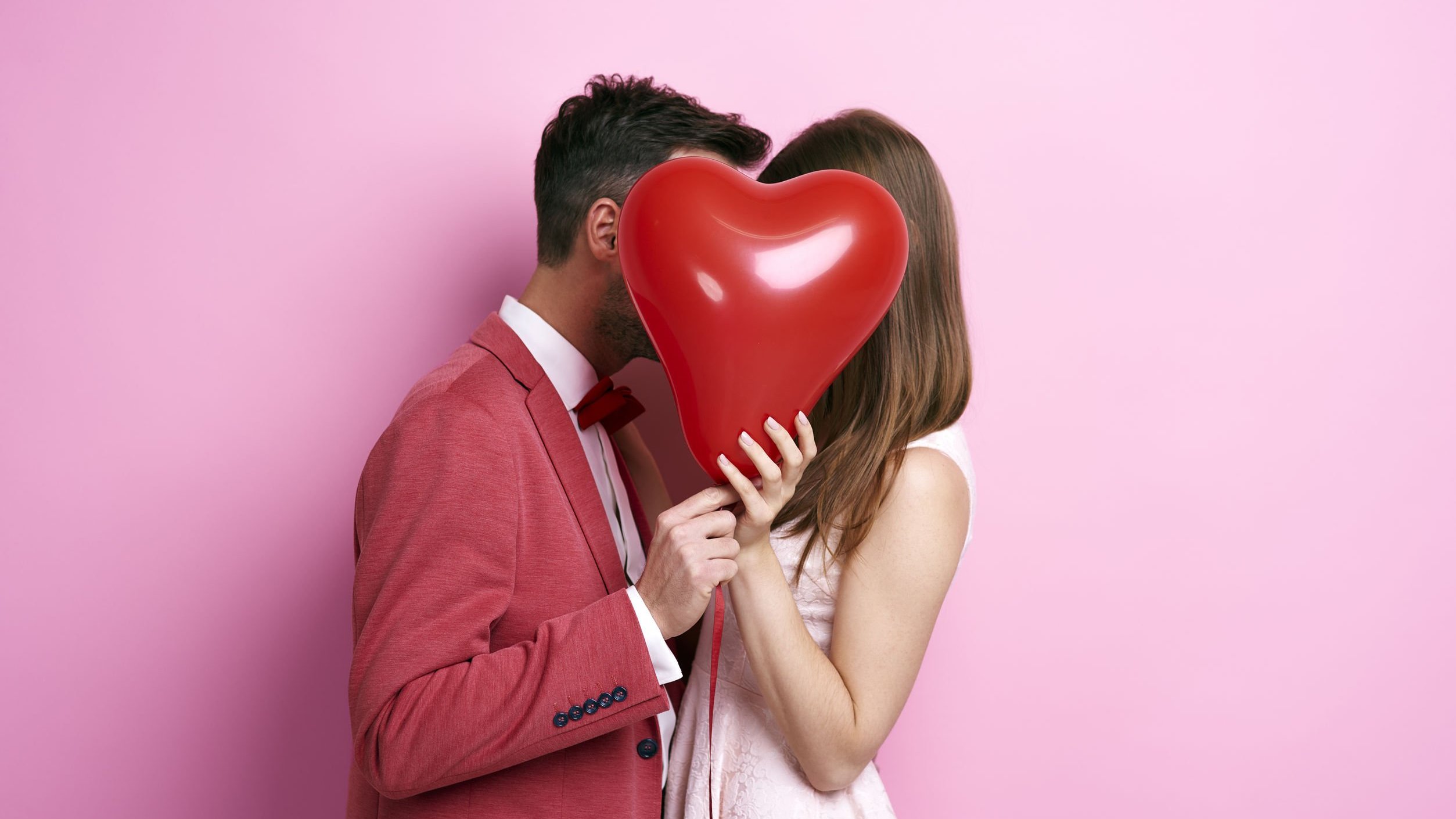 Homem e mulher segurando balão em forma de coração