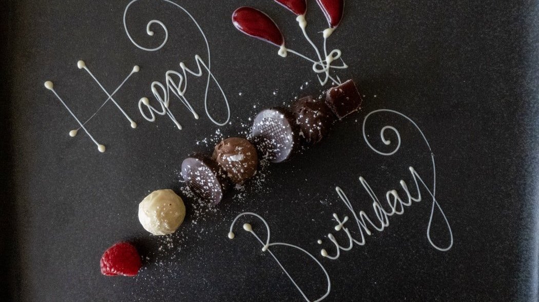 Feliz aniversário escrito com chocolate em prato, em inglês