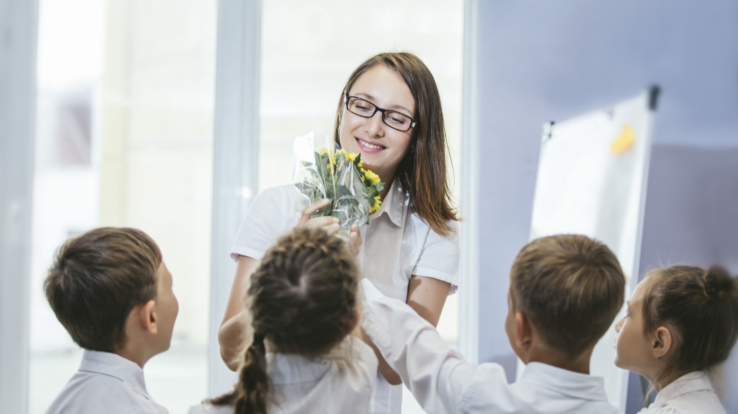 Alunos dando flores para professora