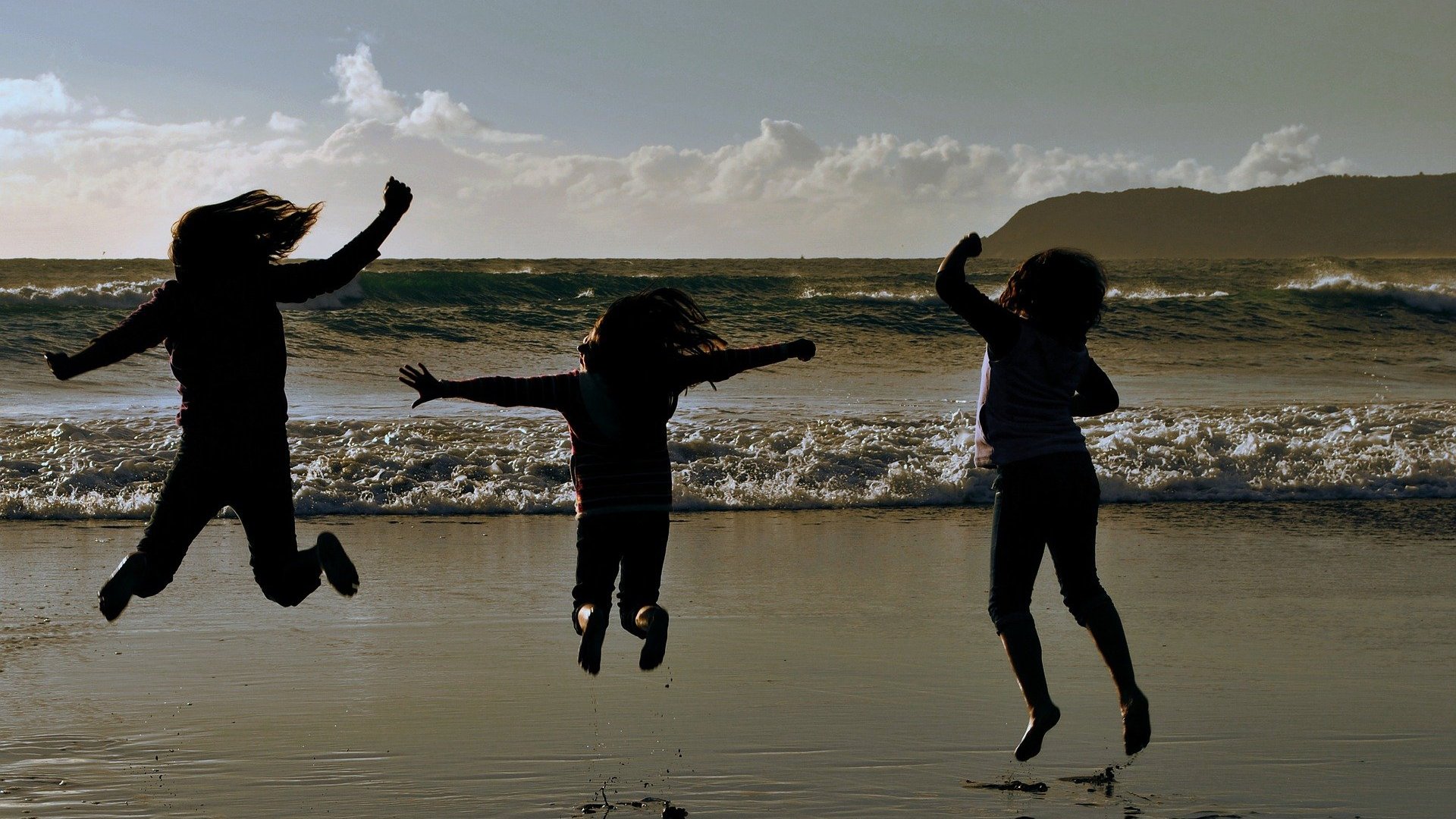 felipeguerrero85/ Pixabay Silhueta de três pessoas pulando em praia