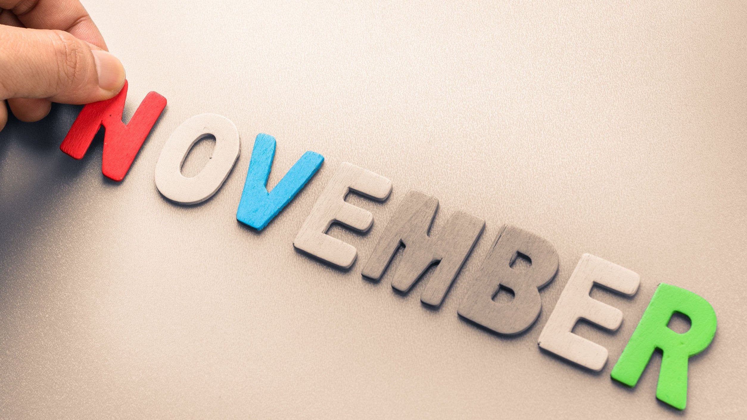 Novembro escrito em inglês com letras coloridas feitas de feltro