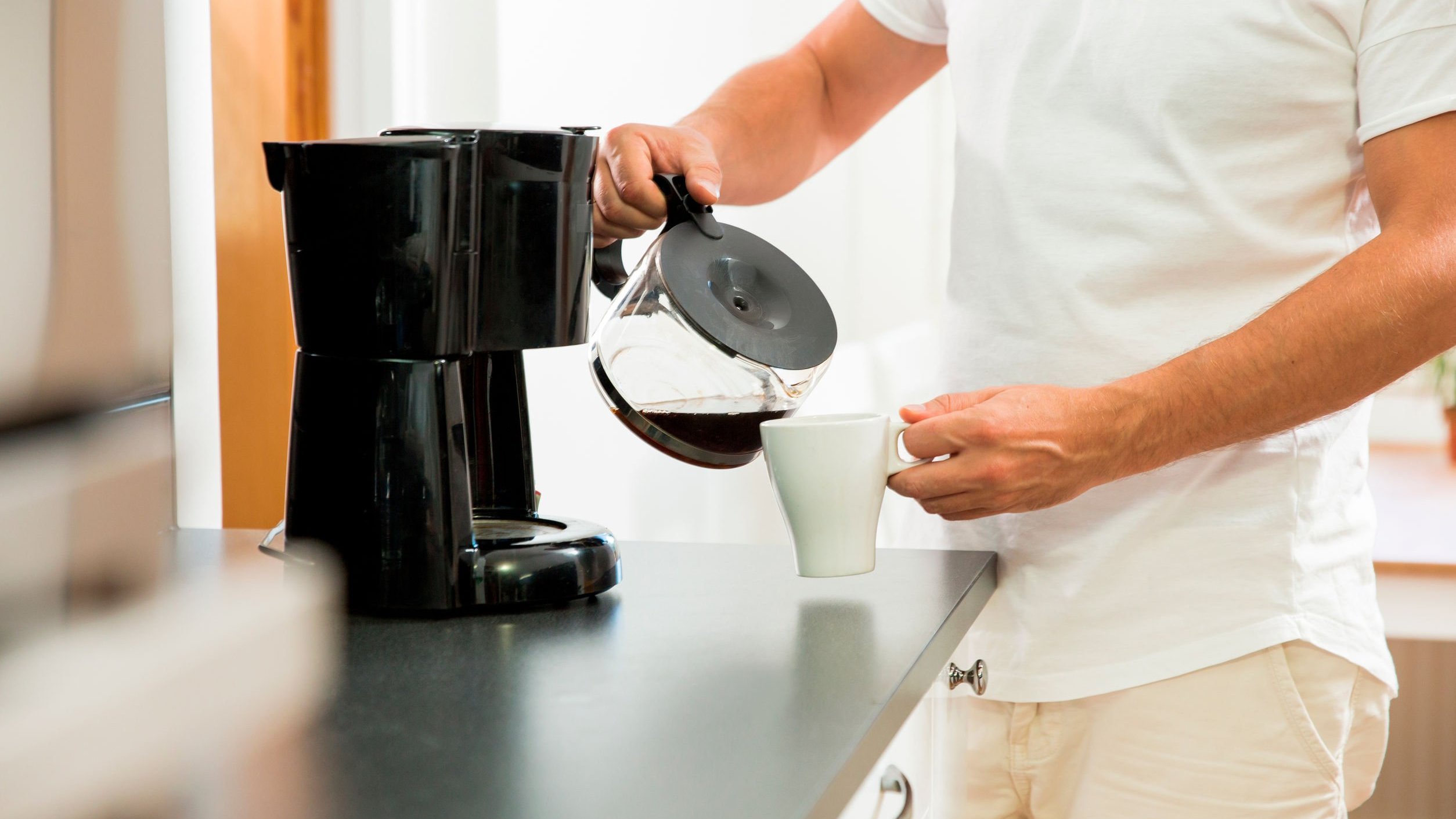 Homem colocando café em xícara