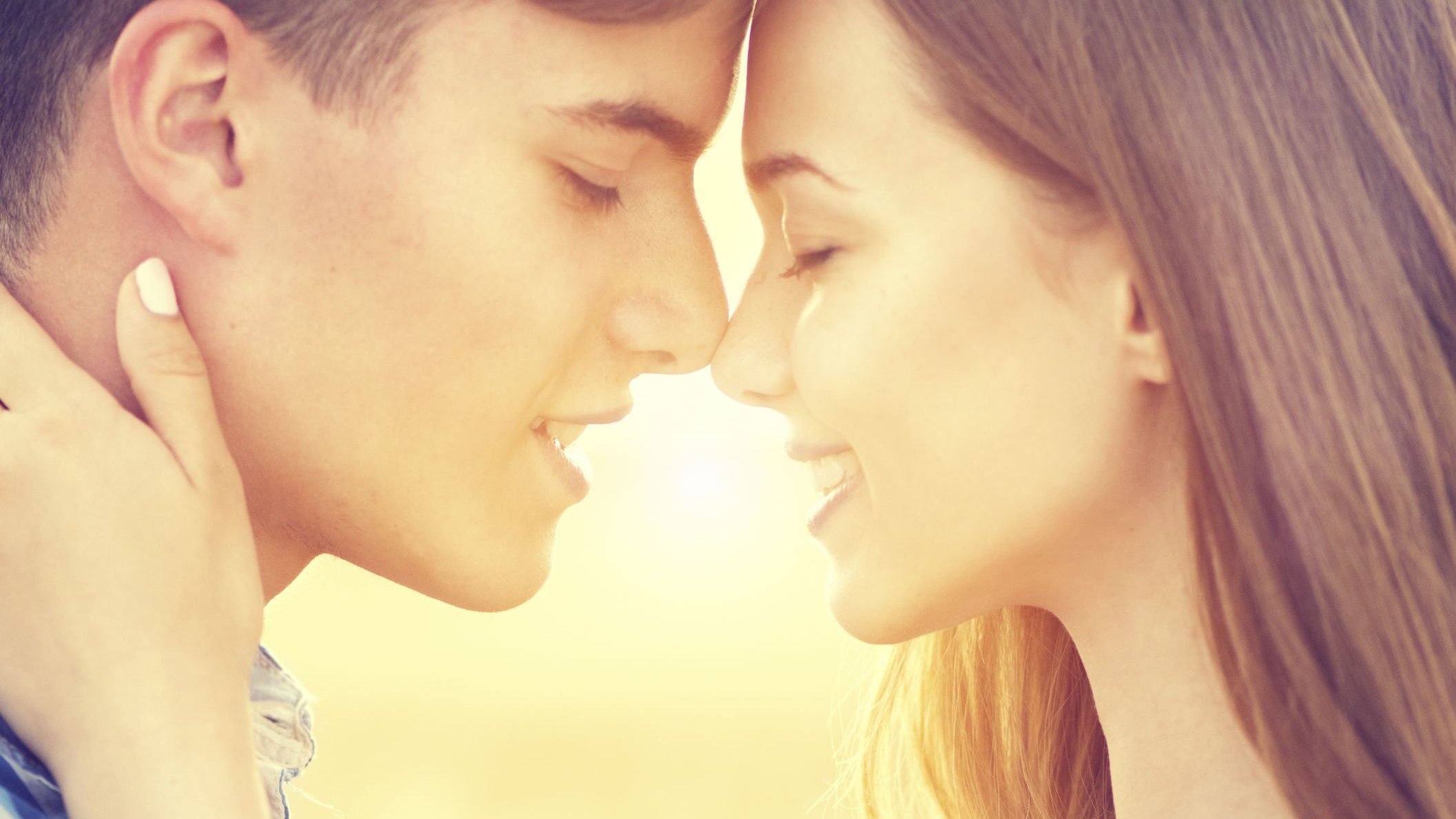 Homem e mulher abraçados sorrindo quase se beijando