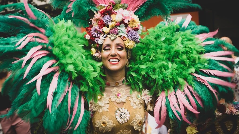 Ugur Arpaci/ Unsplash Passista de carnaval, com fantasia de carnaval, sorrindo