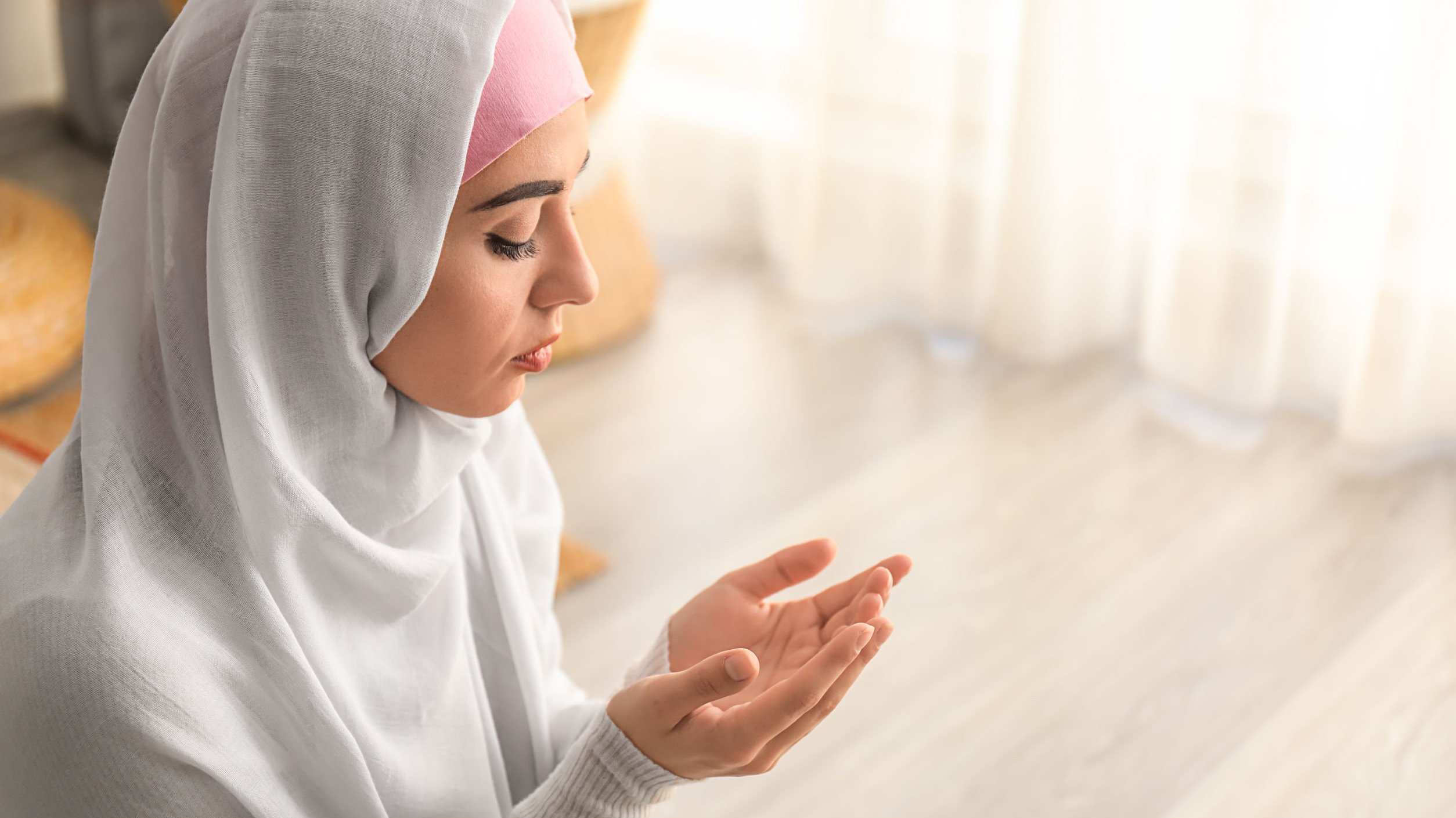 serezniy/123RF Mulher usando roupas tradicionais do islamismo orando ajoelhada no chão