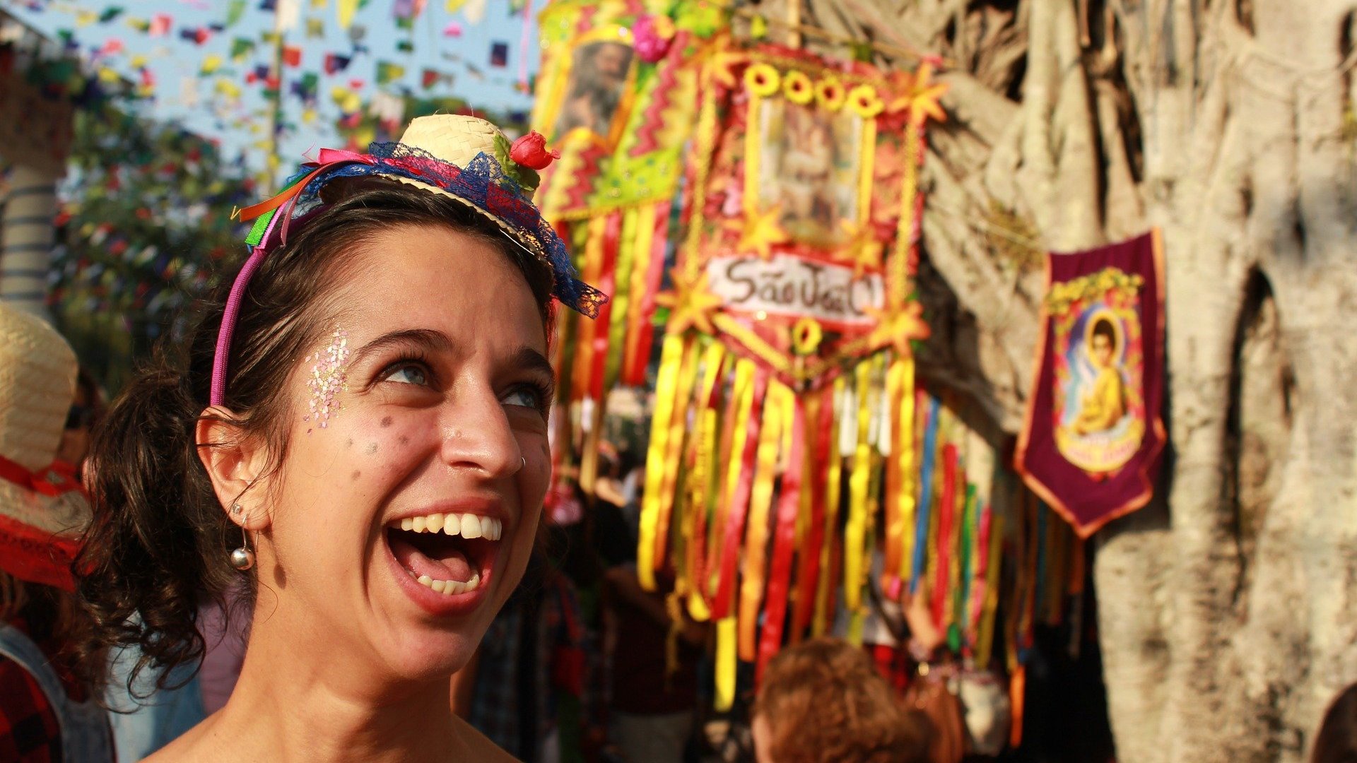 Mulher vestida com roupas de festa junina sorrindo olhando para cima