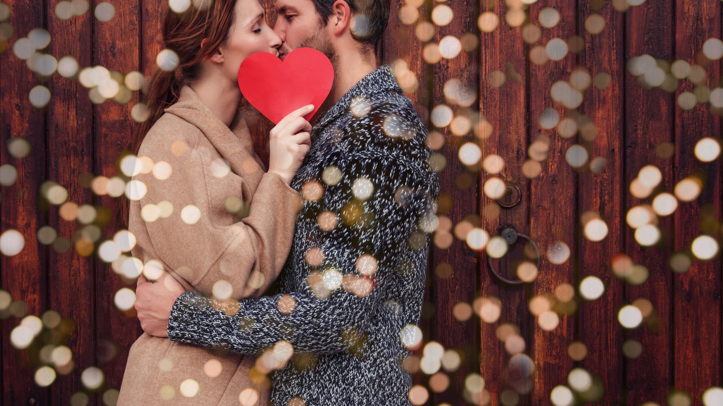 Casal se beijando e mulher segurando papel em formato de coração