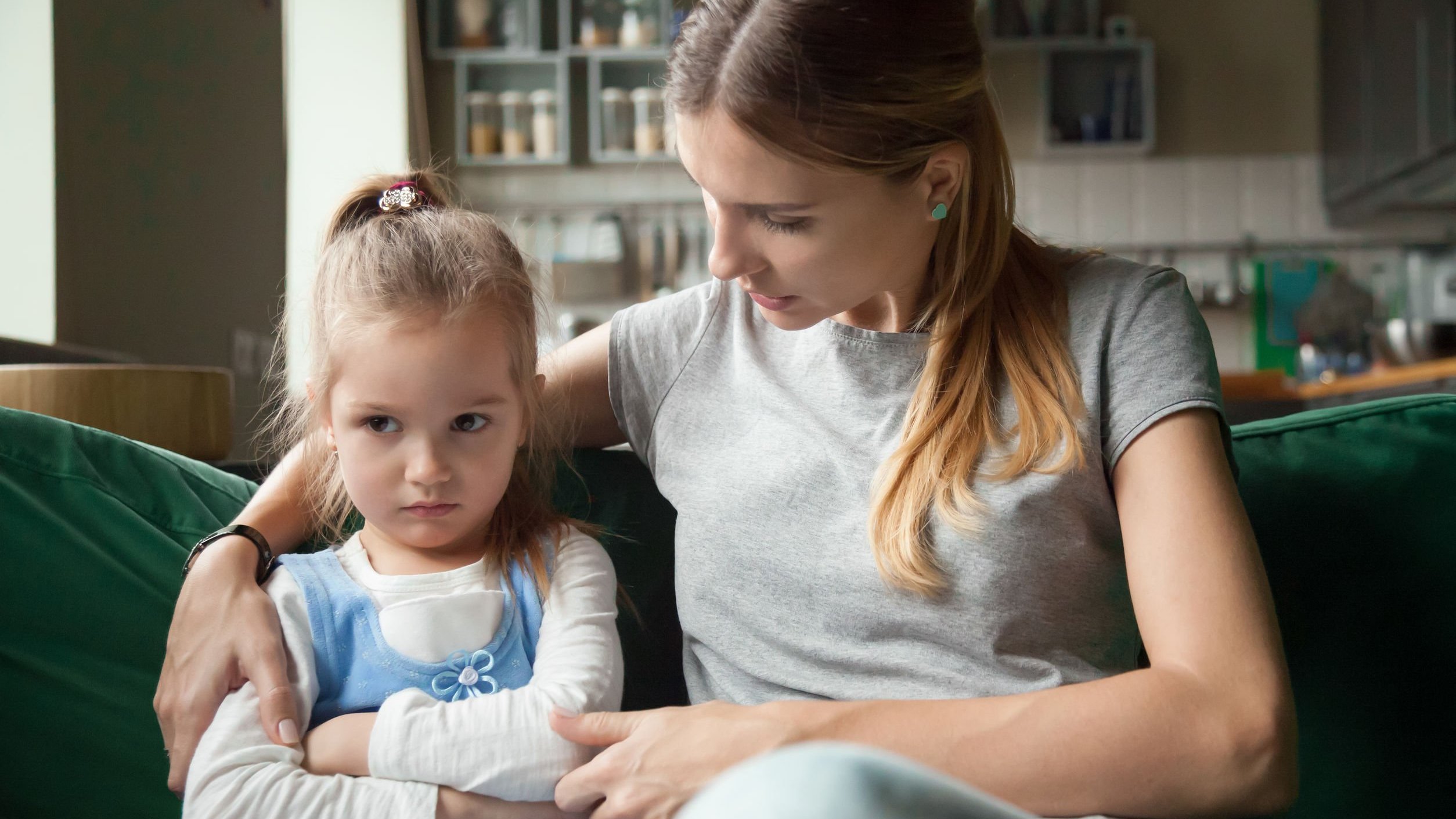 Mãe e filha sentadas em sofá conversando