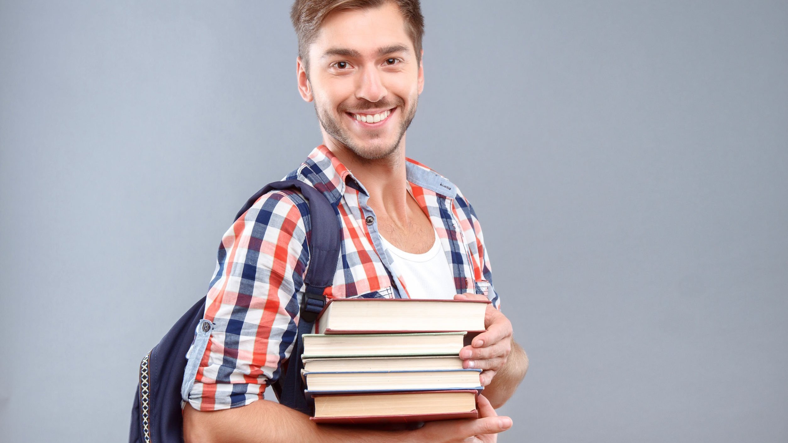 Homem sorrindo segurando livros