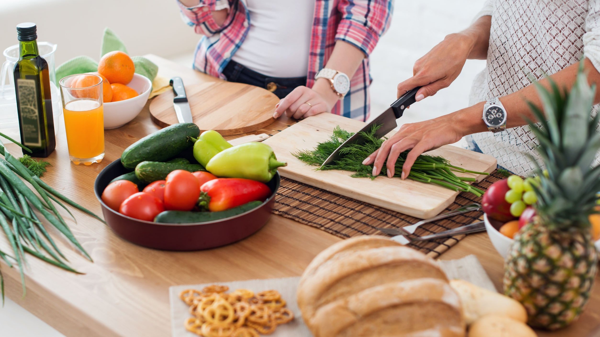 Pessoas cortando alimentos para cozinhar