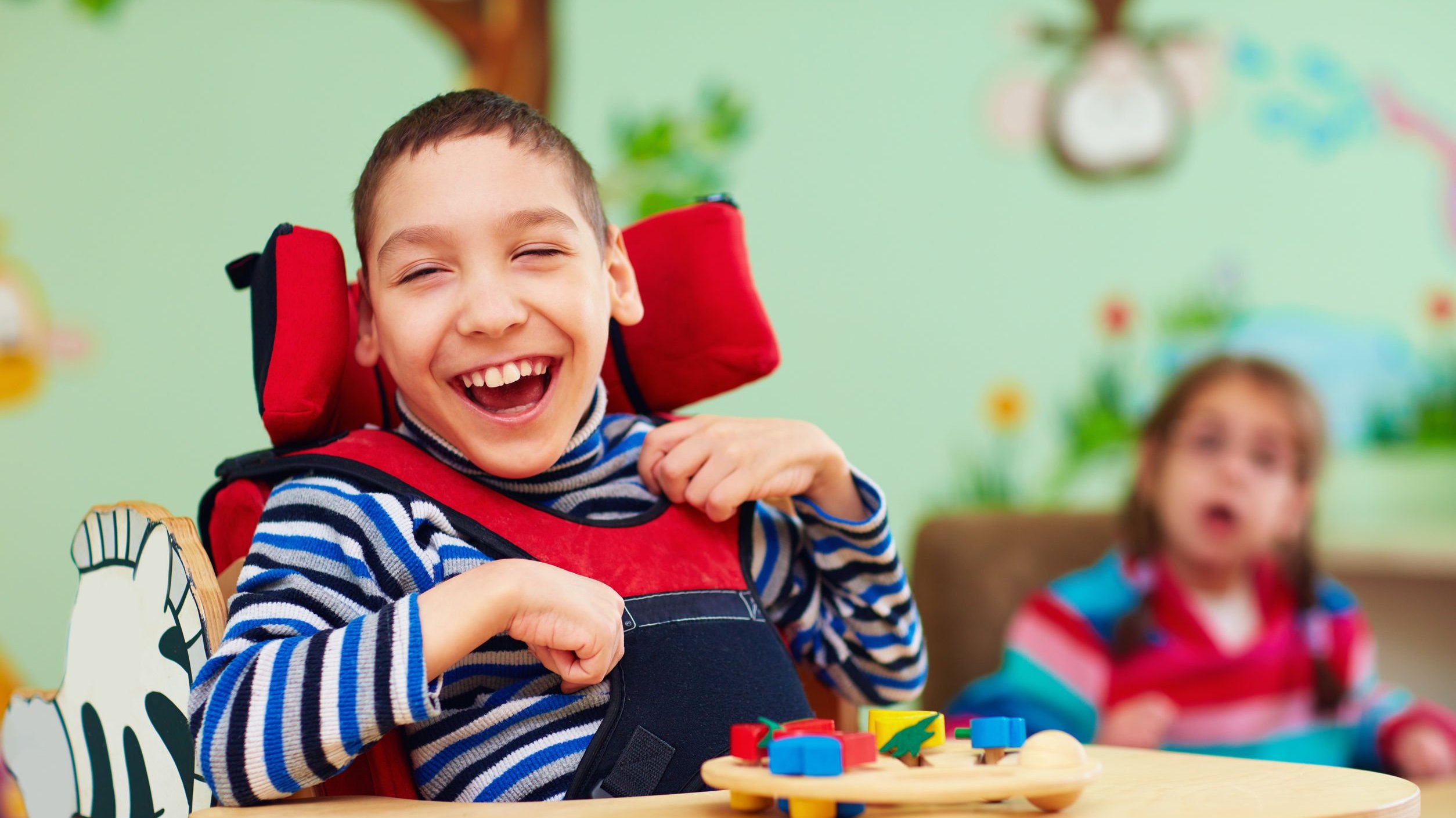 Criança com deficiência sorrindo em cadeira de rodas
