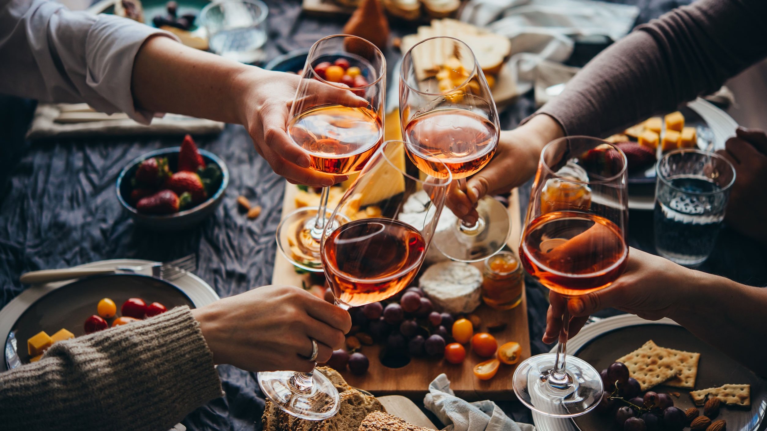 Mãos de pessoas brindando com taças de vinho