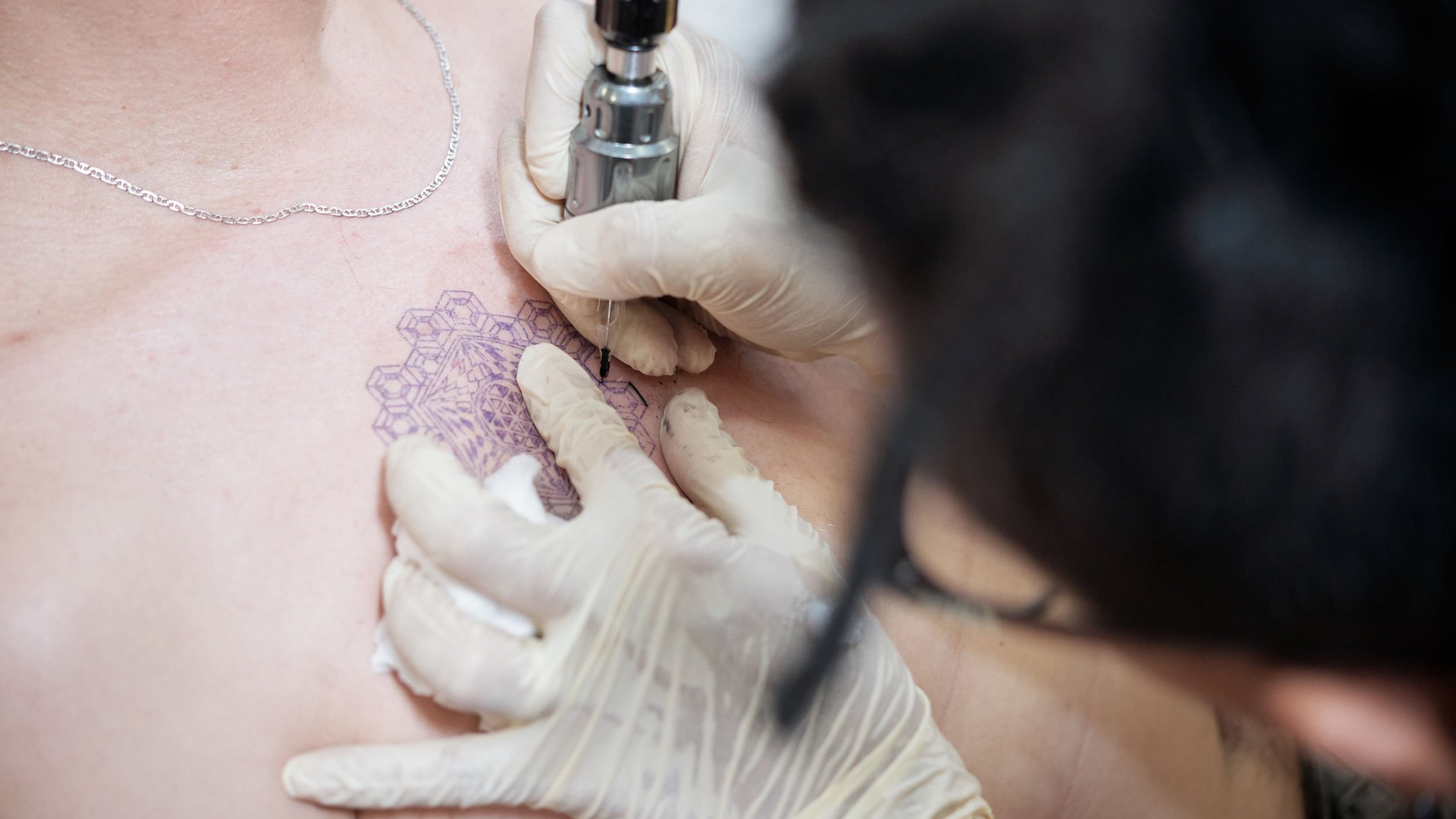 Tatuador fazendo tatuagem em homem