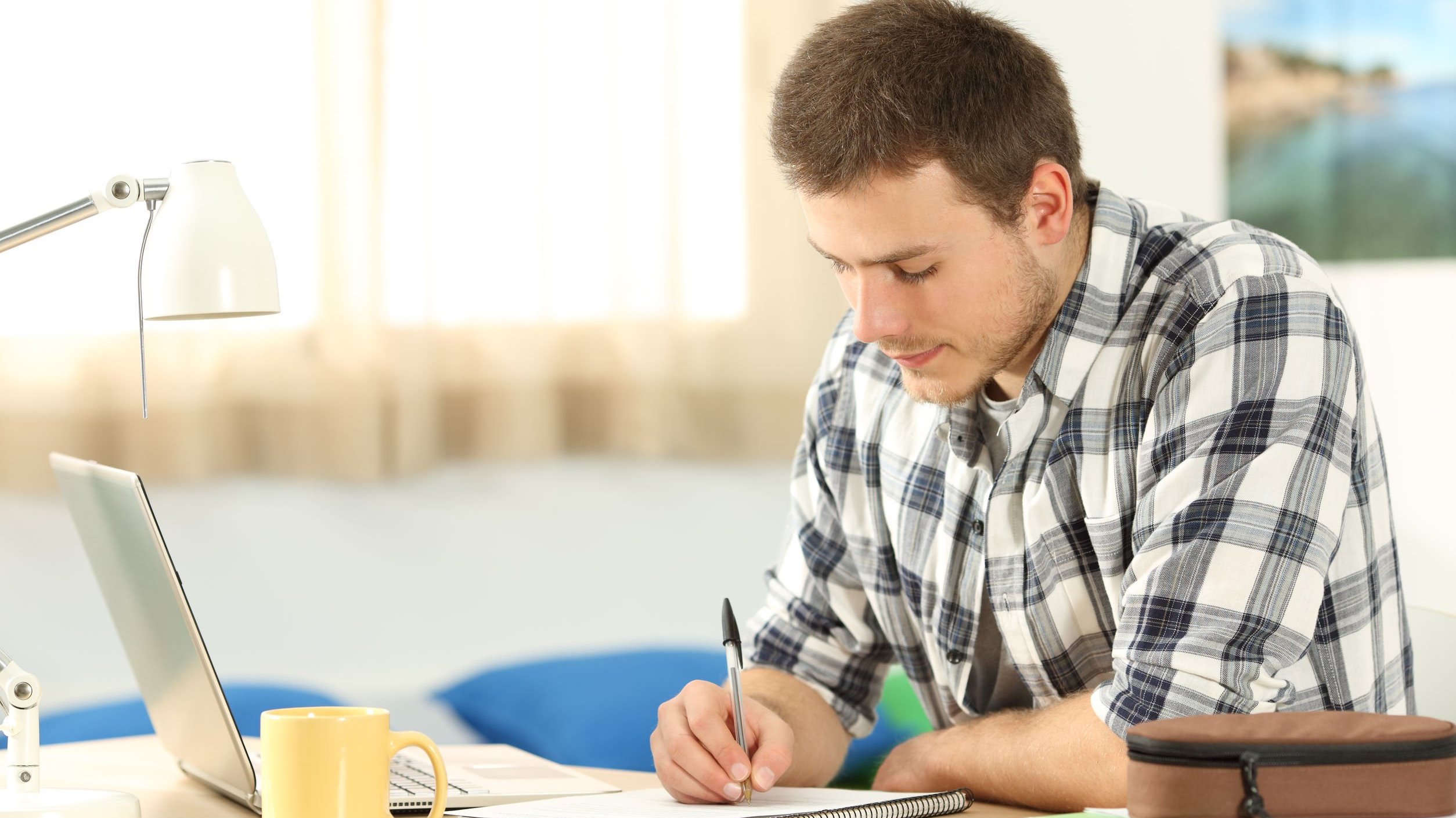 Homem estudando em uma mesa, em casa