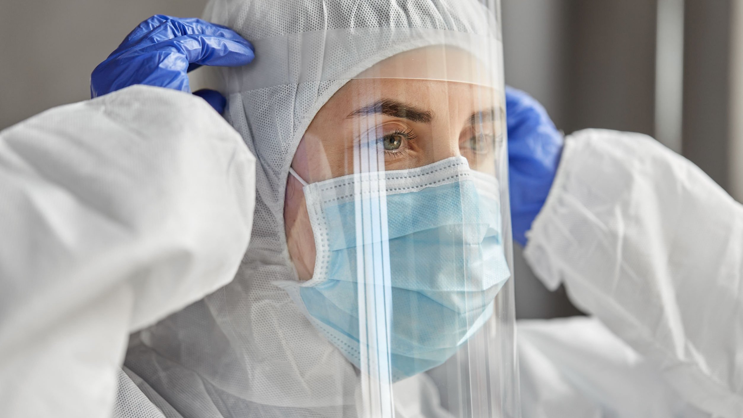 Profissional da saúde colocando seu material de proteção facial